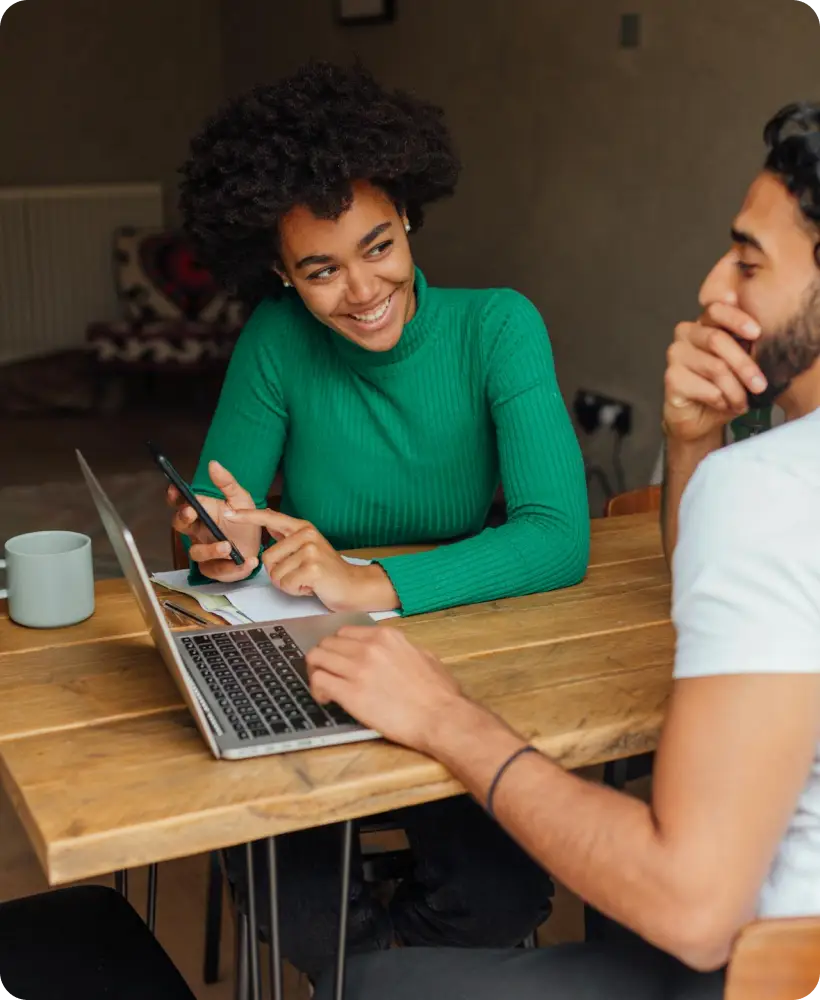 Two colleagues reviewing information together on a laptop